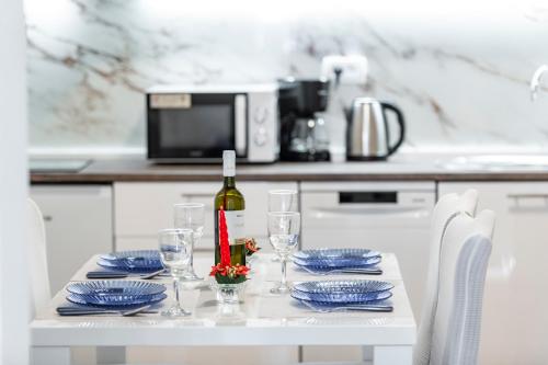 a white table with a bottle of wine and glasses at Apartment Ivo & Mare in Dubrovnik