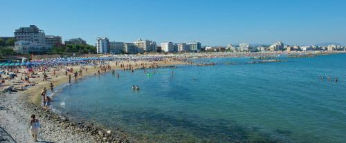 a beach with a lot of people in the water at Hotel Mirò in Cattolica