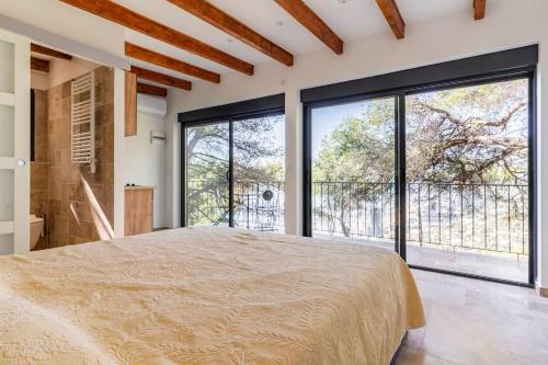 una camera con un grande letto e ampie finestre di Maison exceptionnelle a Roquebrune-Cap-Martin