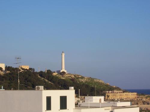 a white building with a lighthouse on a hill at Leukos in Leuca