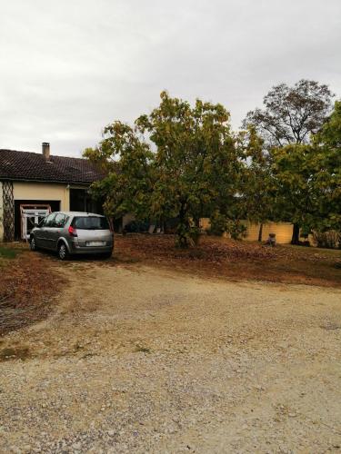 une voiture garée devant une maison dans l'établissement Gîte du Gouthé, à Le Brouilh