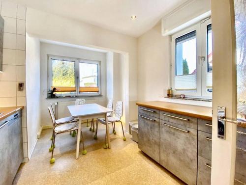 a kitchen with a table and chairs and two windows at Apartment Avanzato in Erfurt