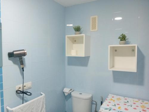 baño con aseo y pared azul en Apartamento Luna, en Gandía