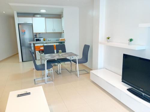 a living room with a table and chairs and a kitchen at Apartamento Luna in Gandía