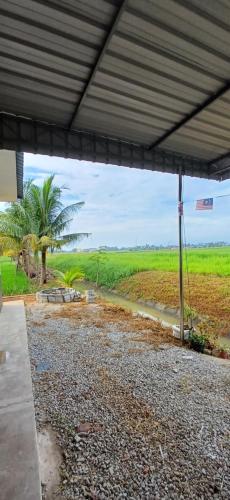 una vista de un campo desde debajo de un edificio en Inap Hujung kampung en Penaga