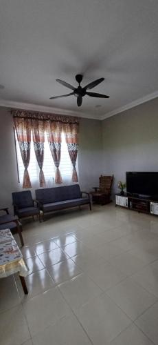 a living room with a couch and a ceiling fan at Inap Hujung kampung in Penaga