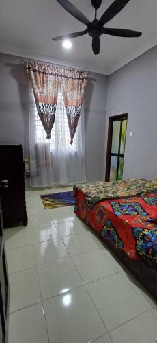 1 dormitorio con 1 cama y ventilador de techo en Inap Hujung kampung en Penaga
