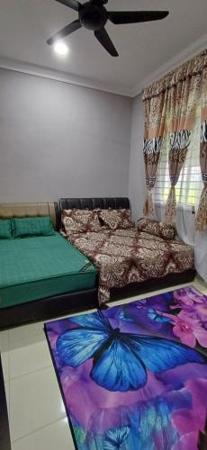 a bedroom with two beds and a butterfly rug at Inap Hujung kampung in Penaga