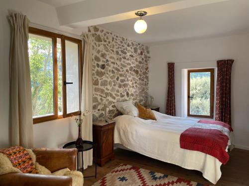 une chambre avec un lit, une chaise et des fenêtres dans l'établissement Cozy Catalan Cottage, à Reynès