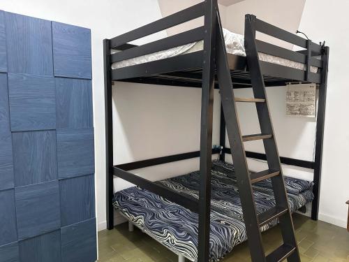 a black bunk bed in a room with a ladder at Monolocale Comodo alla Metro in Turin