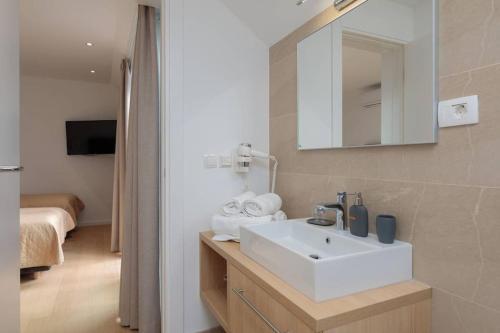 a bathroom with a sink and a mirror and a bed at 5-star modern stone villa Sea La Vie in Sutivan