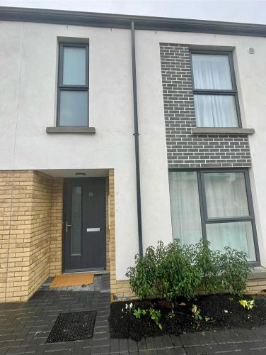 une maison blanche avec une porte et des fenêtres noires dans l'établissement Private cozy room in Dublin, à Dublin