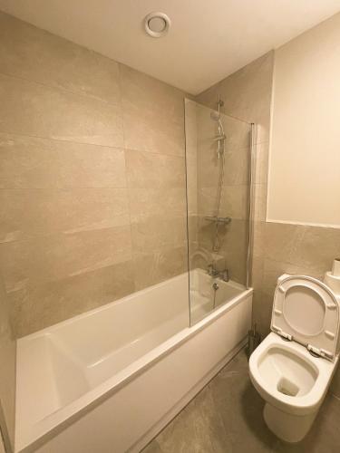 La salle de bains est pourvue d'une douche, de toilettes et d'une baignoire. dans l'établissement Private cozy room in Dublin, à Dublin