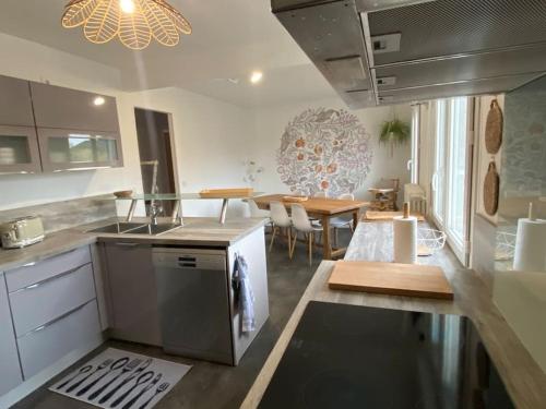 a kitchen and dining room with a table and a dishwasher at Le Coty - Appartement -St Marie des champs in Sainte-Marie-des-Champs
