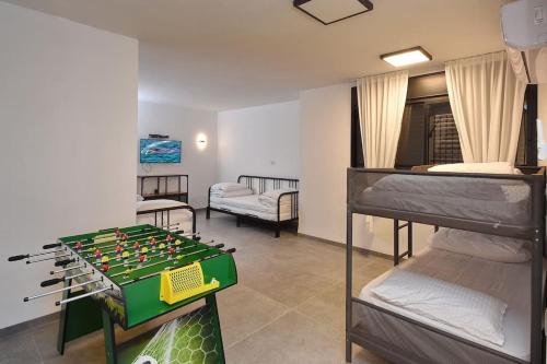 a room with a foosball table and two bunk beds at וילה אליה in Migdal