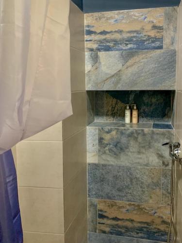 a bathroom with a shower with a shower curtain at La Maison du Belvédère in Essaouira