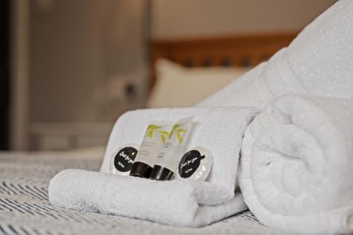 a pile of towels sitting on top of a bed at Queensferry Guest house in Rosyth