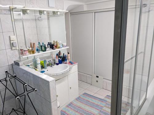 une salle de bain avec un lavabo et un miroir dans l'établissement Chambre dans maison prés du stade de France et piscine olympique, à Franconville