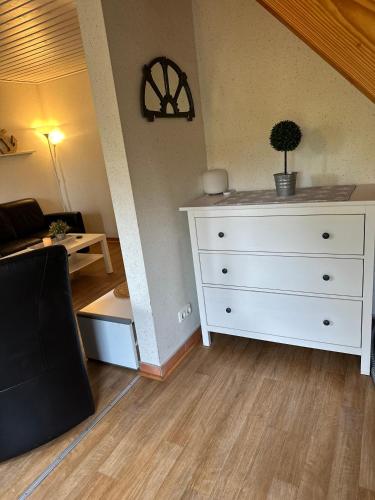 a living room with a white dresser with a plant on it at Ferienhaus Leuchtturm in Fehmarn