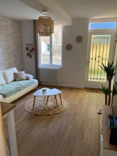 un salon avec un canapé et une table basse dans l'établissement Maison de charme, à Ambleny