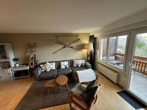 - un salon avec un canapé et une table dans l'établissement Appartement 4.5 pièces Crans-Montana, à Lens