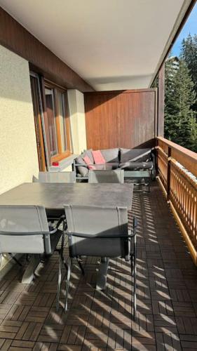 a room with a table and chairs on a balcony at Appartement 4.5 pièces Crans-Montana in Lens