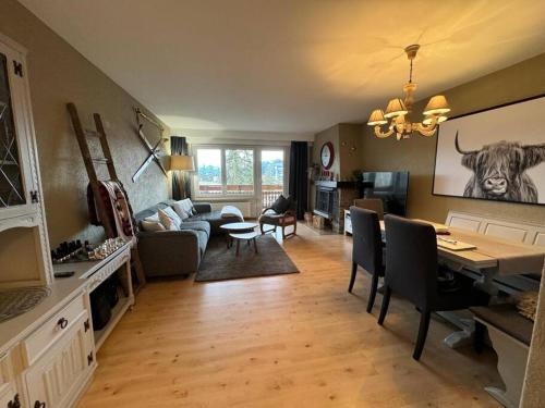 a living room with a couch and a table with chairs at Appartement 4.5 pièces Crans-Montana in Lens