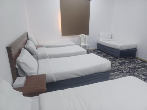 Cette chambre comprend trois lits et un canapé. dans l'établissement عمارة درة السلطان, à Ash Shishah