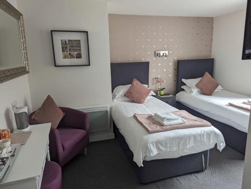una camera d'albergo con due letti e una sedia di The Bulls Head Hotel a Manchester
