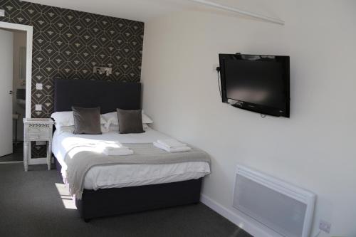 a bedroom with a bed and a flat screen tv at The Bulls Head Hotel in Manchester
