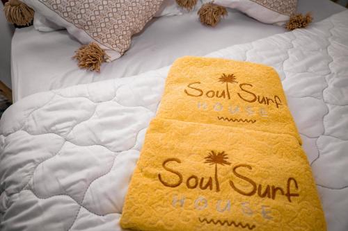 a bed with a yellow blanket on top of it at Soul Surf House in Agadir