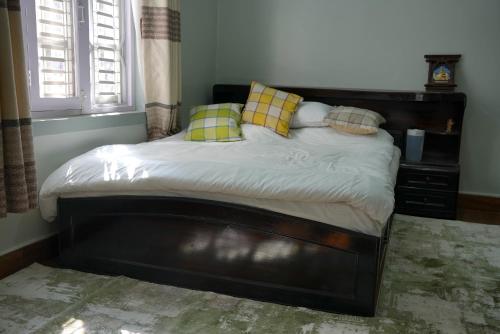 een bed met kussens in een slaapkamer bij Anita's Home -2 in Kathmandu