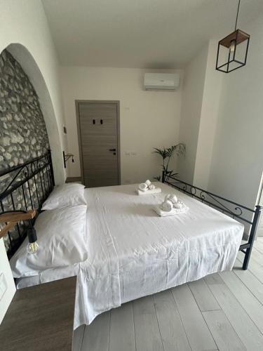 Dimora Dante في أمانتيا: غرفة نوم بسرير ابيض كبير عليها مناشف