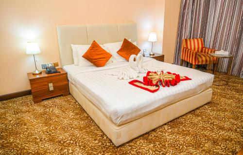a hotel room with a bed with presents on it at GREEN GARDEN HOTEL in Doha
