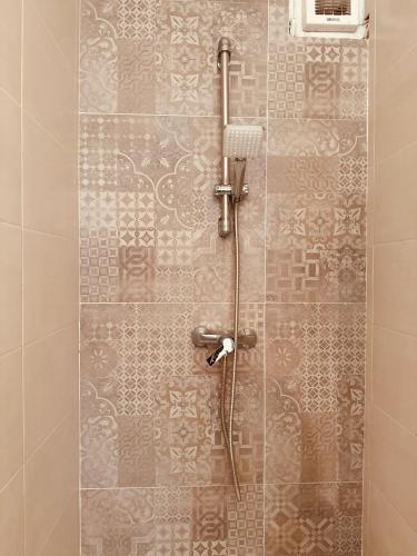 a shower in a bathroom with a tile wall at THERANCOBAY - lake view apartment - in Ranco