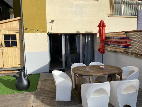 a patio with a wooden table and white chairs at appartement Terrasse 1 chambre ORDINO HUT3-008298 in Ordino