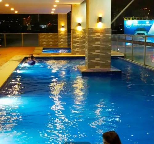 a swimming pool in a building with people in it at Sarado do not book here please in Cebu City
