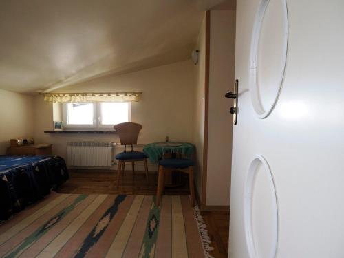 a room with a bed and a table and chairs at Villa Romano in Kielce