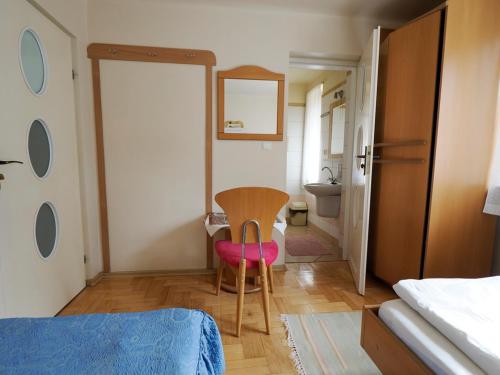a bedroom with a table and a chair and a bathroom at Villa Romano in Kielce