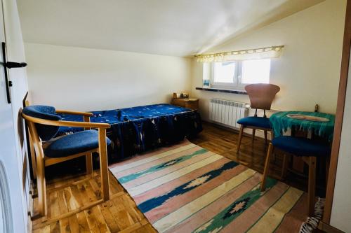 キェルツェにあるVilla Romanoのベッド1台、椅子2脚、ラグ1枚が備わる客室です。