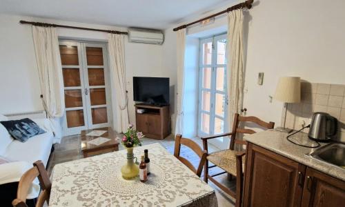 a living room with a table and a kitchen with a room at Aunt Maria's in Pano Lefkara
