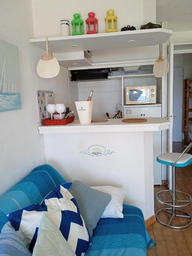 un salon avec un canapé bleu dans une pièce dans l'établissement studio pieds dans l'eau, à Saint-Raphaël