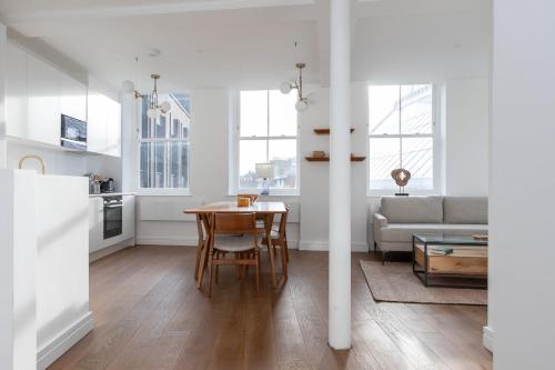 a kitchen and living room with a table and a couch at Luxury 2 Bedroom Huge Duplex Covent Garden Holborn in London