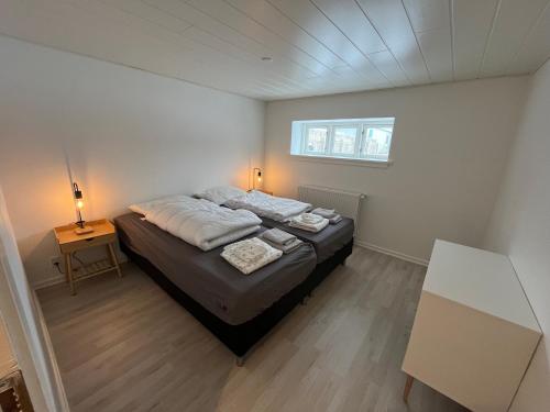 a bedroom with a bed in a room with a window at Skøn lejlighed med egen terrasse og have tæt på centrum i Skagen in Skagen