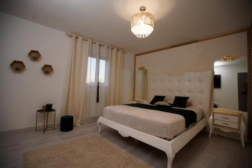 sypialnia z dużym łóżkiem i żyrandolem w obiekcie Magnifique maison de vacances à paris w mieście Paray-Vieille-Poste