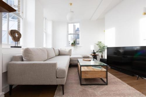 a living room with a couch and a coffee table at Luxury 2 Bedroom Huge Duplex Covent Garden Holborn in London