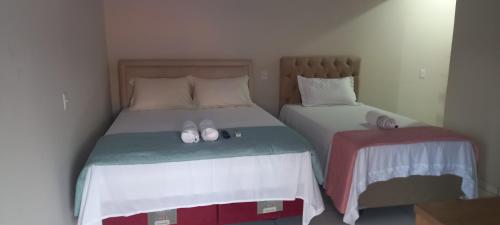 ein Schlafzimmer mit 2 Betten mit Flip-Flops darauf in der Unterkunft Pousada do Sidão in Nobres