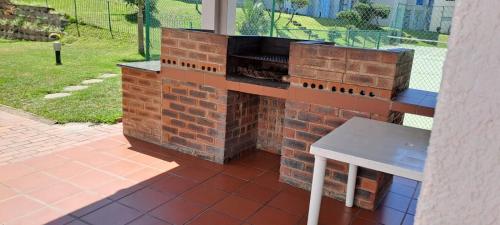 a brick oven on a patio with a white stool at 18 Key Largo Ocean House of Uzurie in Kingsburgh