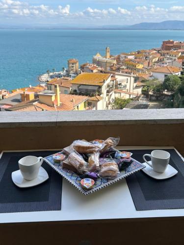 a tray of food sitting on a table with two cups at BILOCALE VISTA MARE CON POSTO AUTO in Porto Santo Stefano