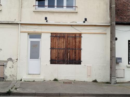 a white building with a wooden door and a window at F1 lumineux in Saint-Pourçain-sur-Sioule